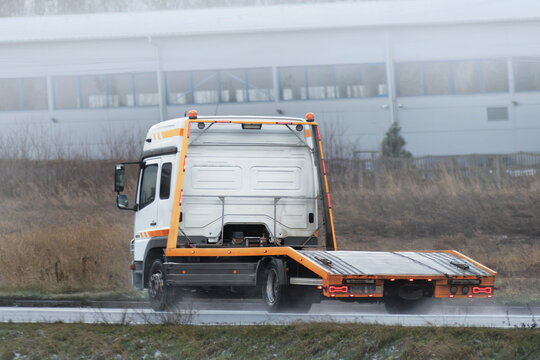A Tow Truck with No Car on Its Platform Driving on the Highway as Part of a Roadside Assistance Business.