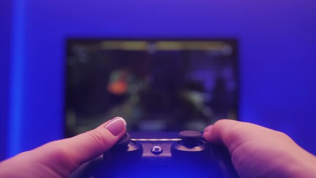 Gamer hands holding modern console for playstation close-up, girl playing video games.