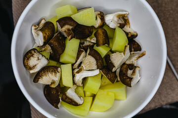 A bowl of diced mushroom and potatoes ready to cook