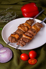 two sticks of lumpy beef kebab on a plate
