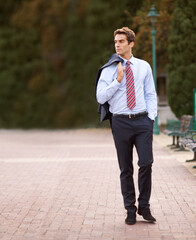 Jacket over his shoulder, business and man walking, park and professional with confidence. Person, outdoor and lawyer with a suit or fresh air with pose or entrepreneur with ideas, decision or choice