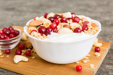 Healthy breakfast food with granola, yogurt, fruits and nuts. Dessert parfait with dried fruits for breakfast