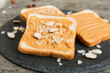 Peanut butter sandwiches or toasts on light table background.Breakfast. Vegetarian food. American cuisine top view vith copy space
