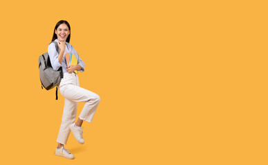 Fototapeta na wymiar Joyful female student with backpack and copybooks smiling