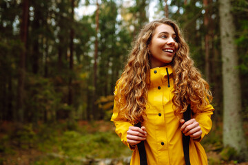 Pretty woman carrying a backpack in the forest  in the autumn season. Traveler enjoying nature....