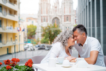 Happy to be together. Attractive elderly family couple sitting in sidewalk cafe.