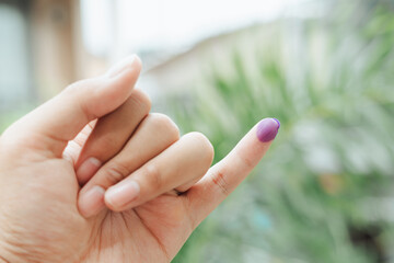 Indonesian man showing little finger covered with ink after giving vote on election or Pemilu