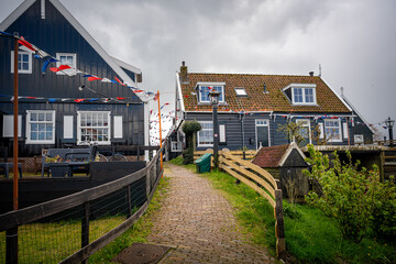 Street filled with flags in the village of Marken with traditional colorful houses in Holland Dutch island peninsula the IJsselmeer Marken on the IJsselmeer in the Netherlands.