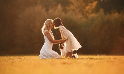 Side view, conception of love and care. Woman with her daughter is on the summer field
