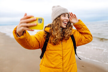 Young woman taking a selfie on the beach. Travelling, lifestyle, adventure. Blogging.