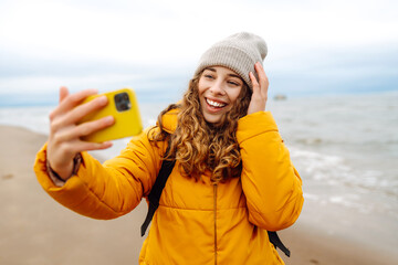 Young woman taking a selfie on the beach. Travelling, lifestyle, adventure. Blogging.