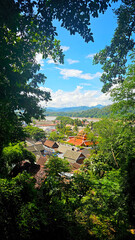 Fototapeta na wymiar A breathtaking view from above of the historical town of Luang Prabang, nestled among lush greenery with the river meandering in the background