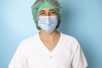 portrait of a nurse in white coat doctor with stethoscope turquoise blue background, with smiling face, making joke