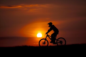 rider and bike silhouetted against setting sun