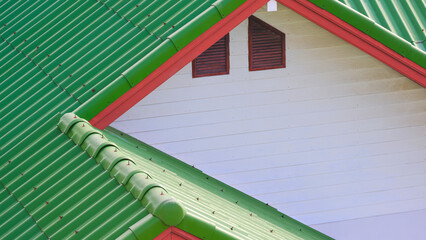 Green concrete tile polygonal roof and white wooden gable combination with 2 attic window of...