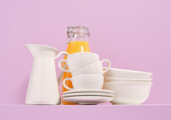Elegant white clean dinnerware and fresh orange juice. Clean plates and other dishes.