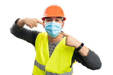 Male builder pointing index fingers at disposable covid19 mask