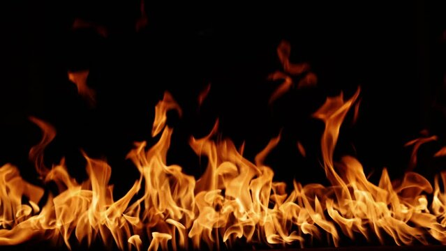 Fire burning. A bright burning fire on a black background. Fire in slow motion. Wall of fire, abstract background