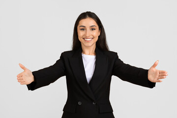 Cheerful young businesswoman welcoming with open arms