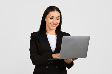 Happy young businesswoman using laptop computer