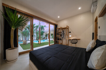 Luxury bedroom including black duvets and washroom entrance through the open door beside the bed...