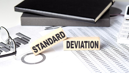 STANDARD DEVIATION - text on a wooden block with chart and notebook