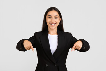 Confident european businesswoman pointing downwards with both hands © Prostock-studio