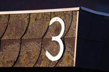 Die Hausnummer drei wird vom Sonnenlicht angestrahlt