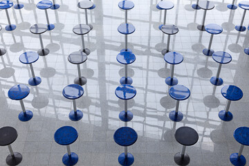 Rows of tall round tables in a lobby, view from above