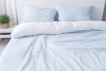 duvet and duvet case on a blue bed. White bed linen on a blue sofa. Bedroom with bed and bedding. Messy bed. Front view