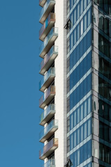 Detail of a modern residential building made of glass, steel and concrete against a clear blue sky