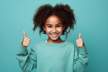 Photo of beautiful brunette cheerful happy young little girl in hoodie, sports warm suit give thumbs up smile recommend isolated on color phone background - obrazy, fototapety, plakaty