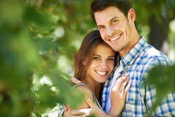 Fototapeta premium Portrait, happy young couple and hug in nature in the park and bonding outdoors in Italy. Love, relationship and travel with romantic partners, getaway date for holiday summer laughing with affection