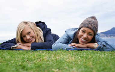 Picnic, grass and portrait of women relax in field with smile, happy and relax on weekend outdoors. Friends, countryside and people in meadow for bonding on holiday, vacation and adventure in nature