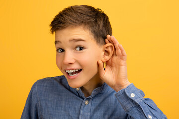 Curious Teen Boy Holding Hand Near Ear Trying To Overhear Something