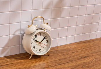 A retro alarm clock stands on the table. Copy space for text.