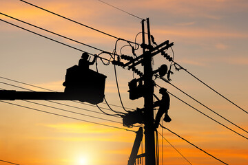 Silhouette of Electrician officer climbs a pole and uses a cable car to maintain a high voltage...