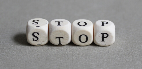 Wooden cubes form the word STOP.