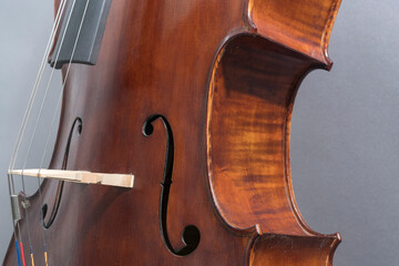 Gebrauchtes , verstaubtes Cello, Detail: Kurve, F-Loch, Steg