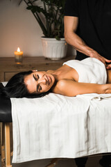 A professional masseur gives a massage to a young woman.Beautiful young woman enjoying massage in spa salon. Beauty treatment, skin care, wellbeing.Concept of massage and spa treatments