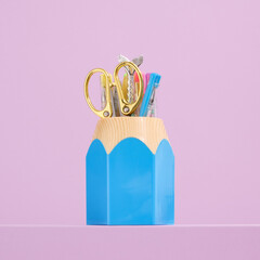 Blue pencil shaped stationery stand. Collection of school supplies.