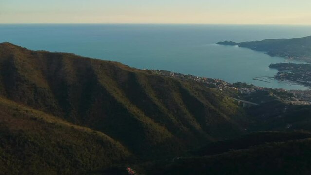drone vista delle colline e della costa in Liguria. Sul fondo Rapallo. Mare e montagne al tramonto.