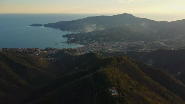 drone vista delle colline in Liguria. Sul fondo Rapallo. Mare e montagne al tramonto.
