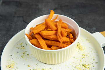 sweet potato fries on white plate on dark background