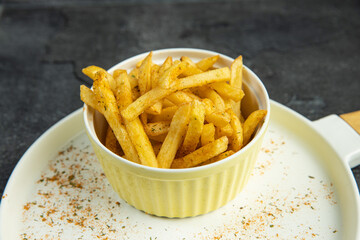 French fries on white plate on dark background