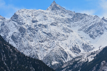 Fototapeta na wymiar Triangular shaped snow capped top mountain rock