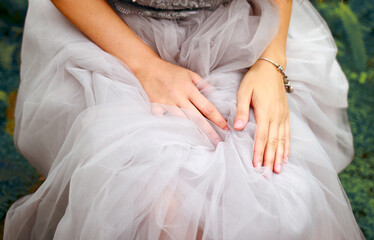 Close-up of women's hands on a tulle skirt. Bride. Event concept