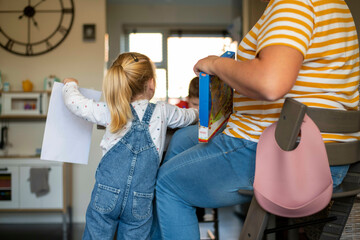 Same sex parents educating their children with puzzles and reading
