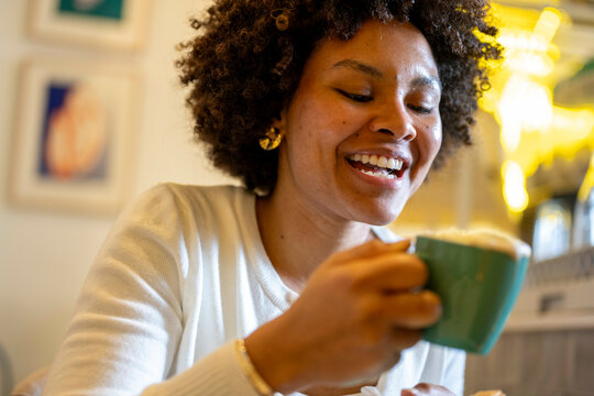 Attractive woman having coffee in a shop laughing with a friend