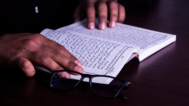 A boy read an Urdu historical book of Islam, urdu manuscript book study concept, book with glass educational concept